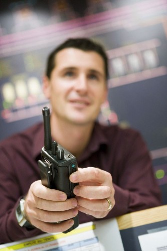 Photo de portrait en reportage pour l'entreprise d'un homme au travail avec un talkie-walkie dans les mains. | Philippe DUREUIL Photographie